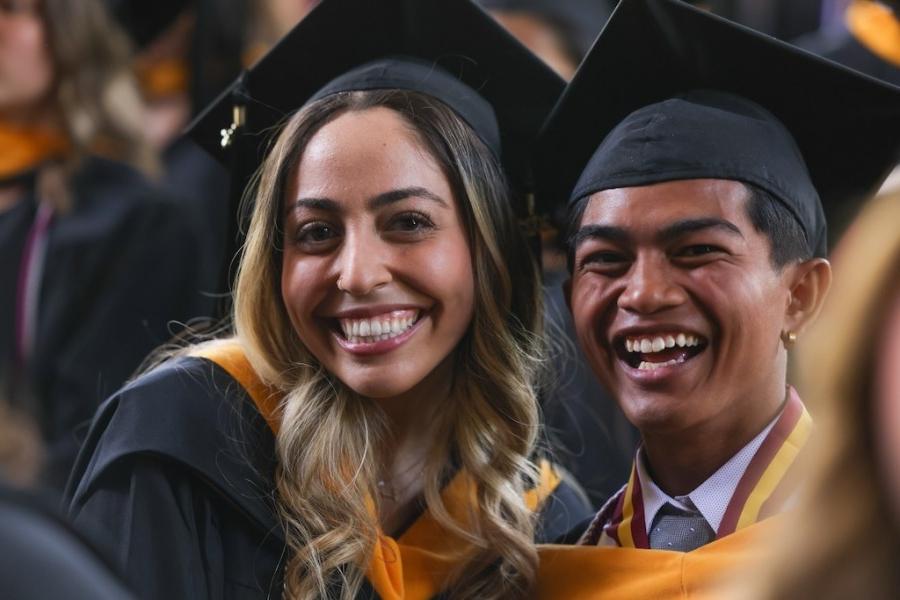 毕业典礼上，两个学生戴着学士帽，面带微笑